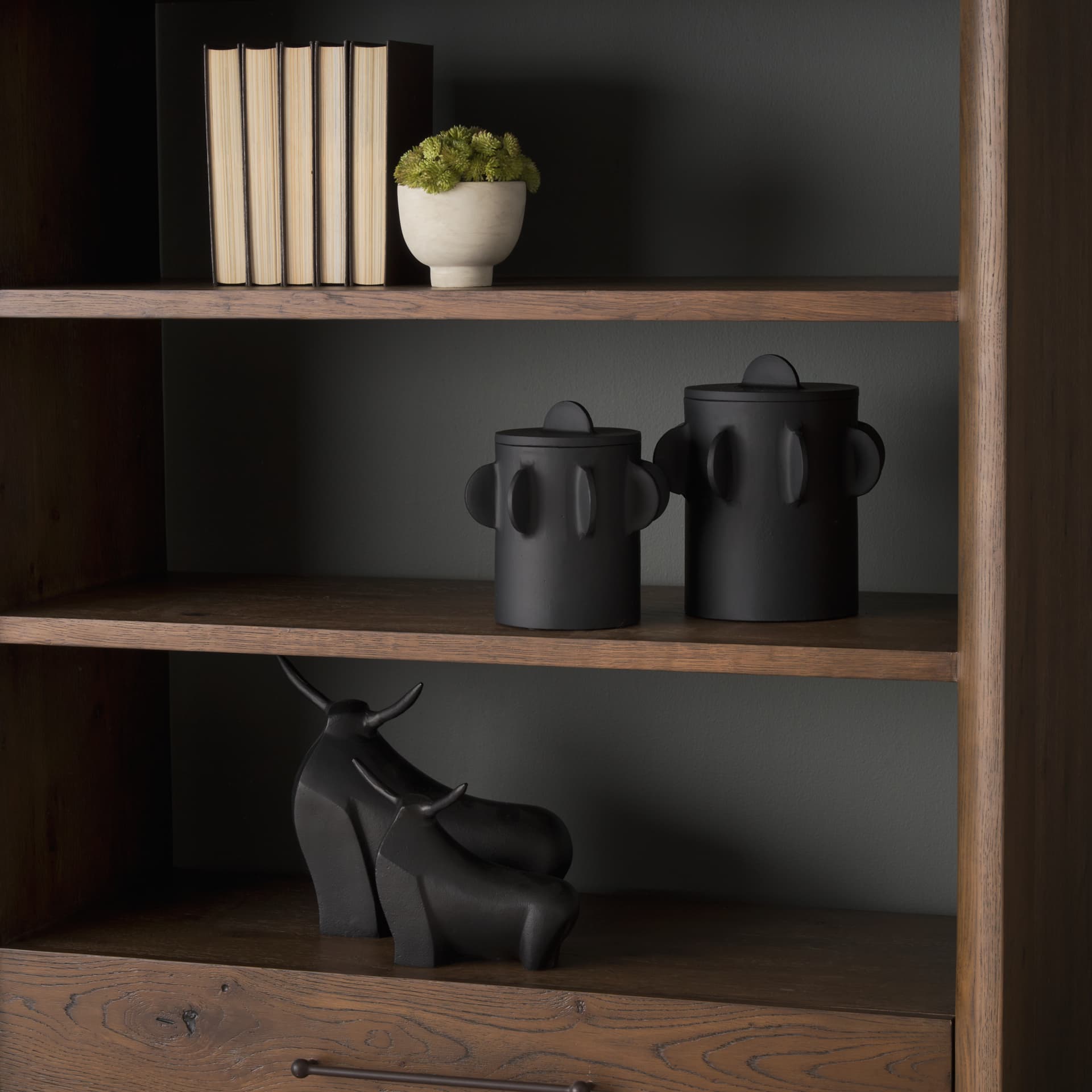 Deacon Small Matte Black Metal Canister with Sculptural Handles — in a styled room