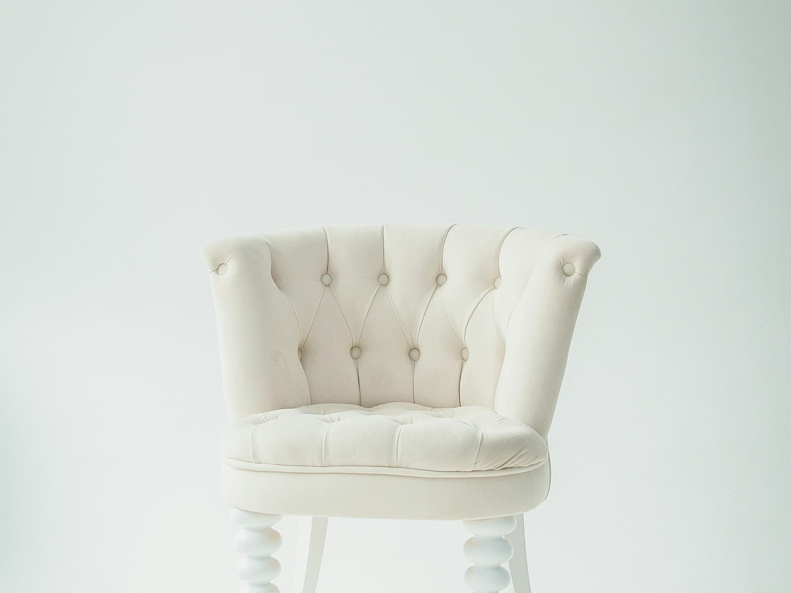 Aster lounge armchair in oat bouclé beside a tall window