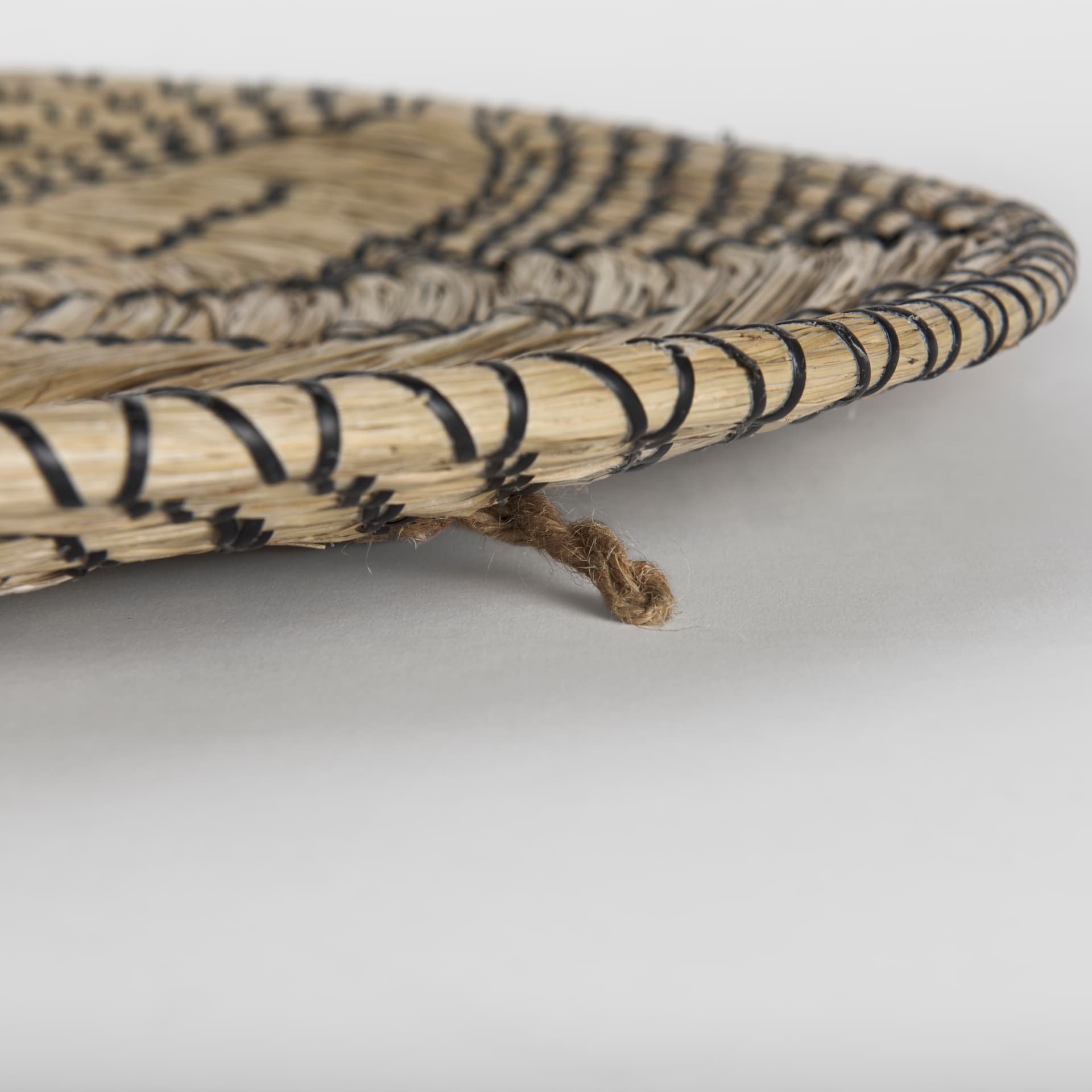 Mekhi 24.0L x 24.0W x 3.5 Light Brown Seagrass W/Black String Round Wall Hanging Plate — product photograph