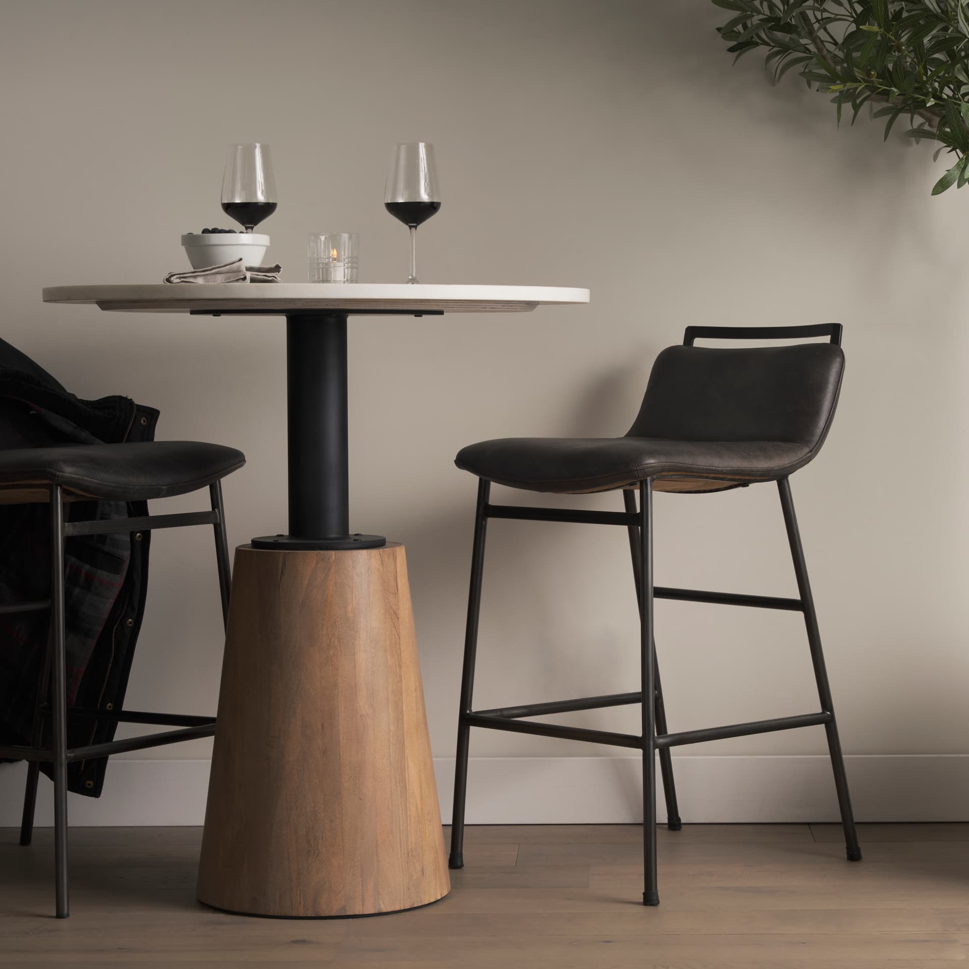 Kavalan Low Back 33.5in Seat Counter Stool | Ebony Leather w/ Metal — in a styled room