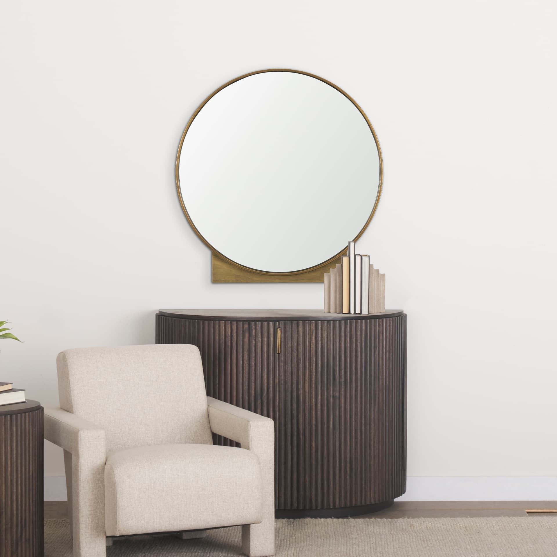 Tillie Round Brushed Gold Metal Frame Wall Mirror — in a styled room