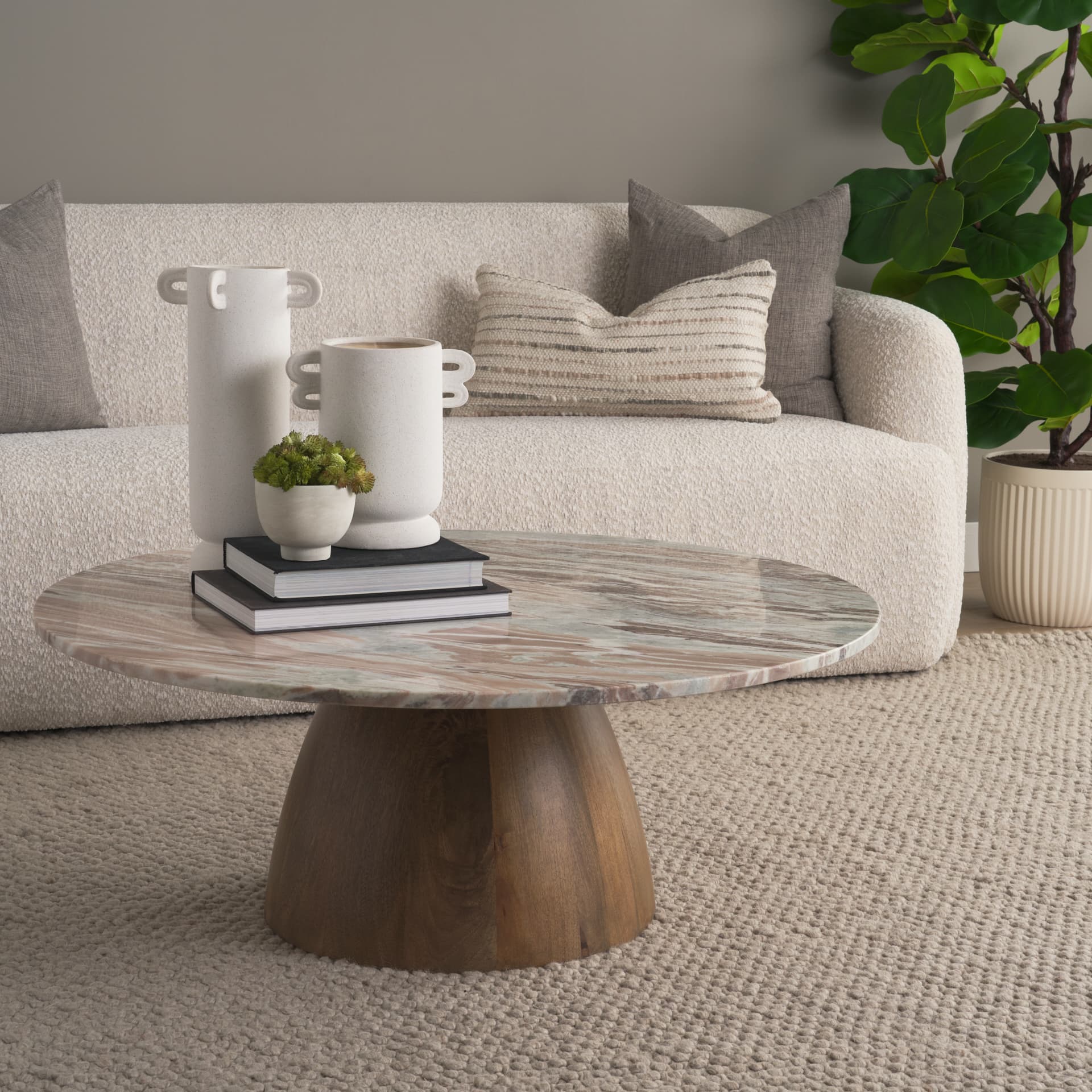 Allyson Round Brown Pedestal w/Savar Pink Marble Top Coffee Table — in a styled room