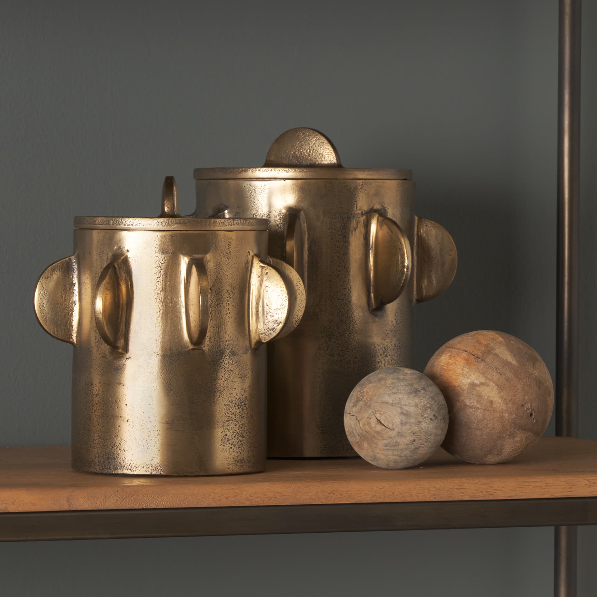 Deacon Small Antiqued Gold Metal Canister with Sculptural Handles — in a styled room