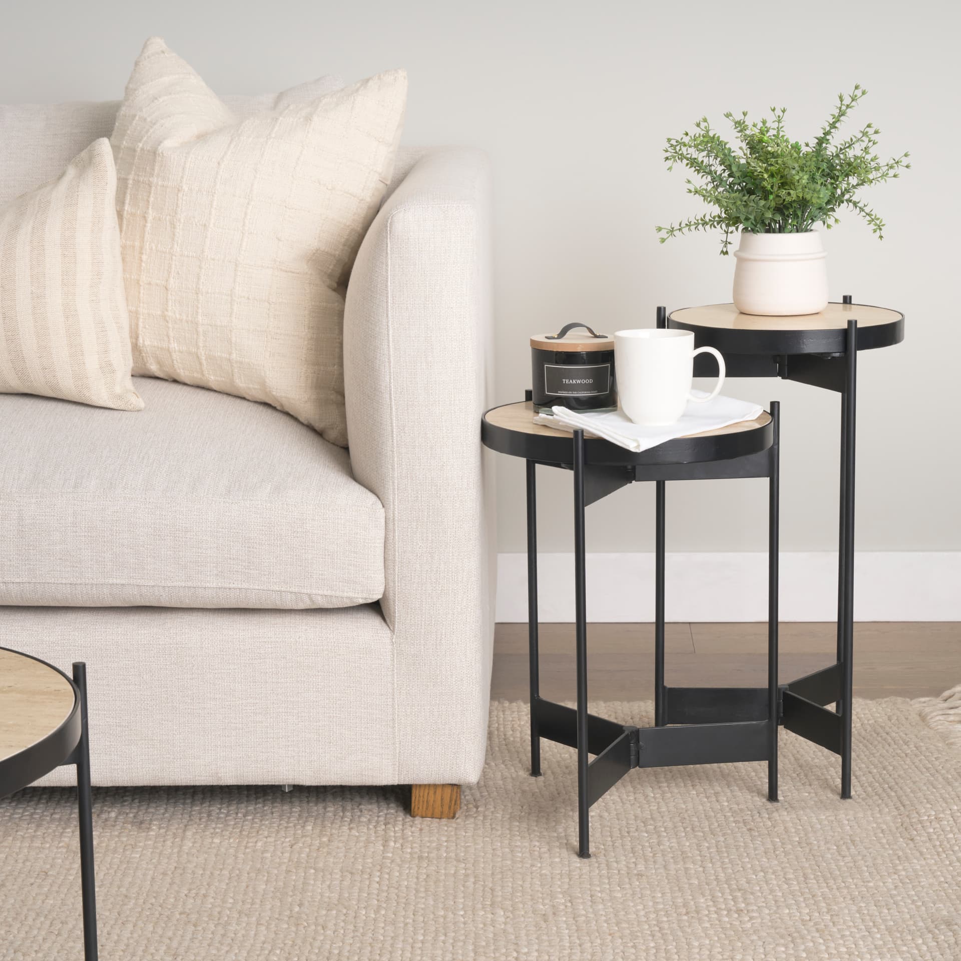 Wade Travertine Marble w/ Matte Black Metal End Tables — in a styled room