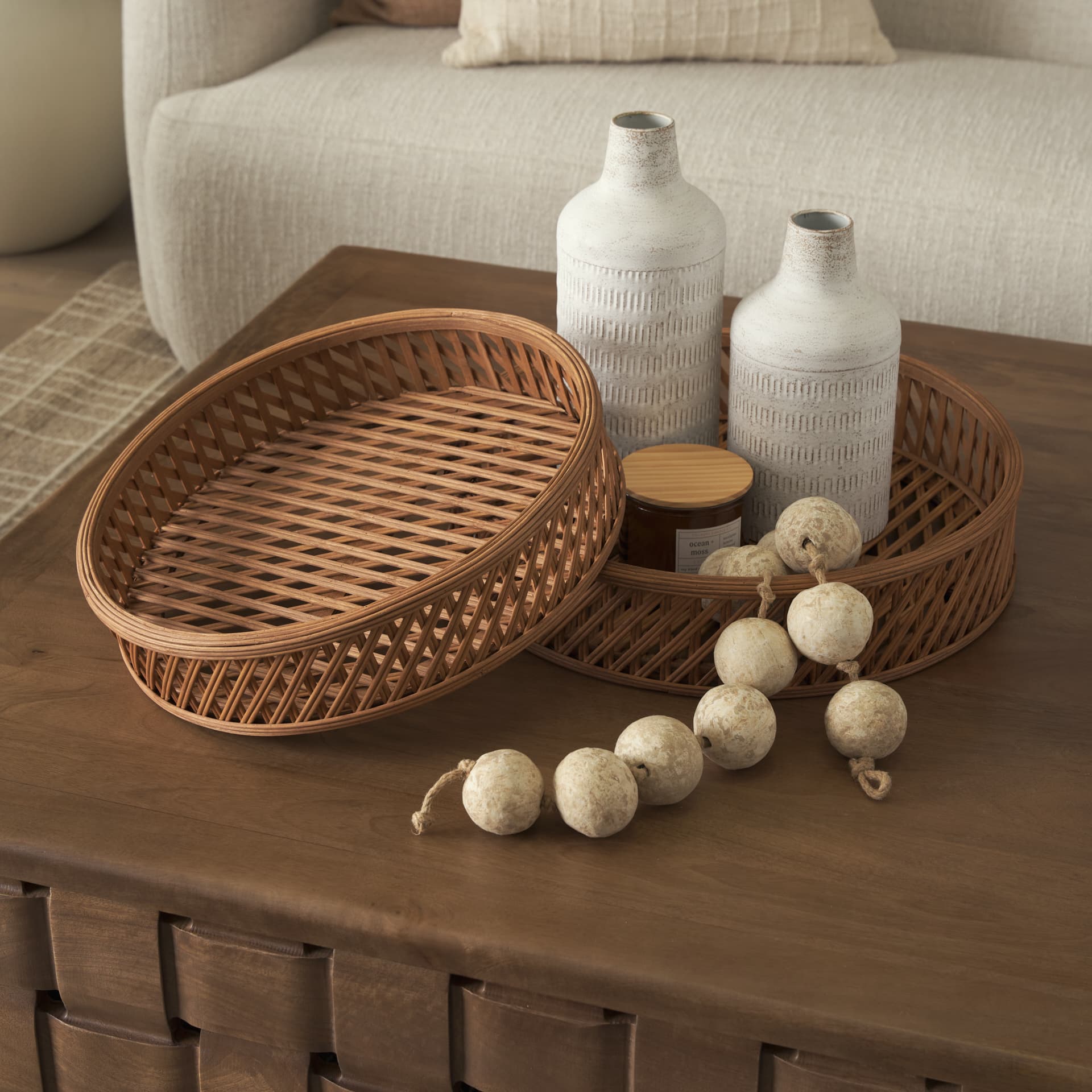 Thala Medium Brown Round Wicker Tray (Set of 2) — in a styled room
